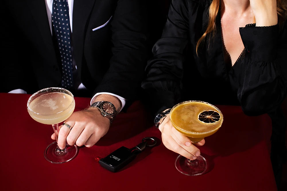 Man and woman with drinks and Andatech GT Fuel Cell Breathalyser at a bar