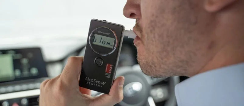 A man blowing into Andatech AlcoSense Zenith+ personal breathalyser