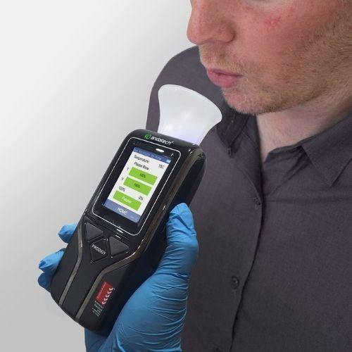 Blowing into the sampling cup of Andatech Prodigy S workplace breathalyser